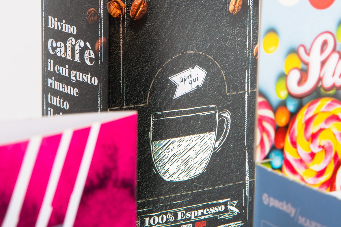 Cropped photo of a box, focusing on the central part with white text and designs on a black background.