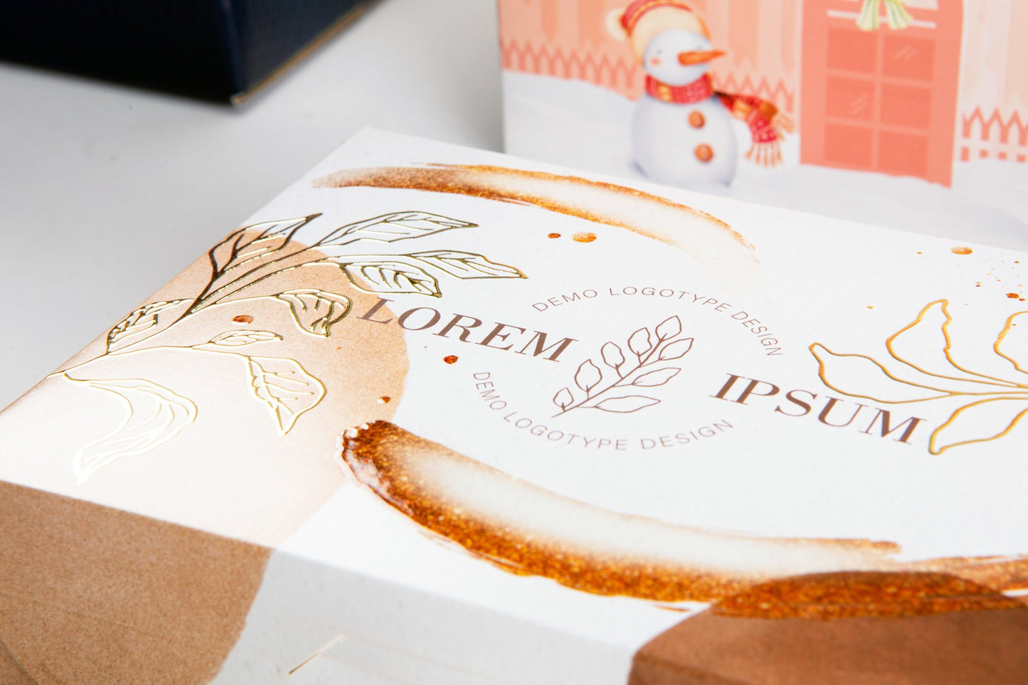 Detail of a white box with gold-embossed leaf designs.
