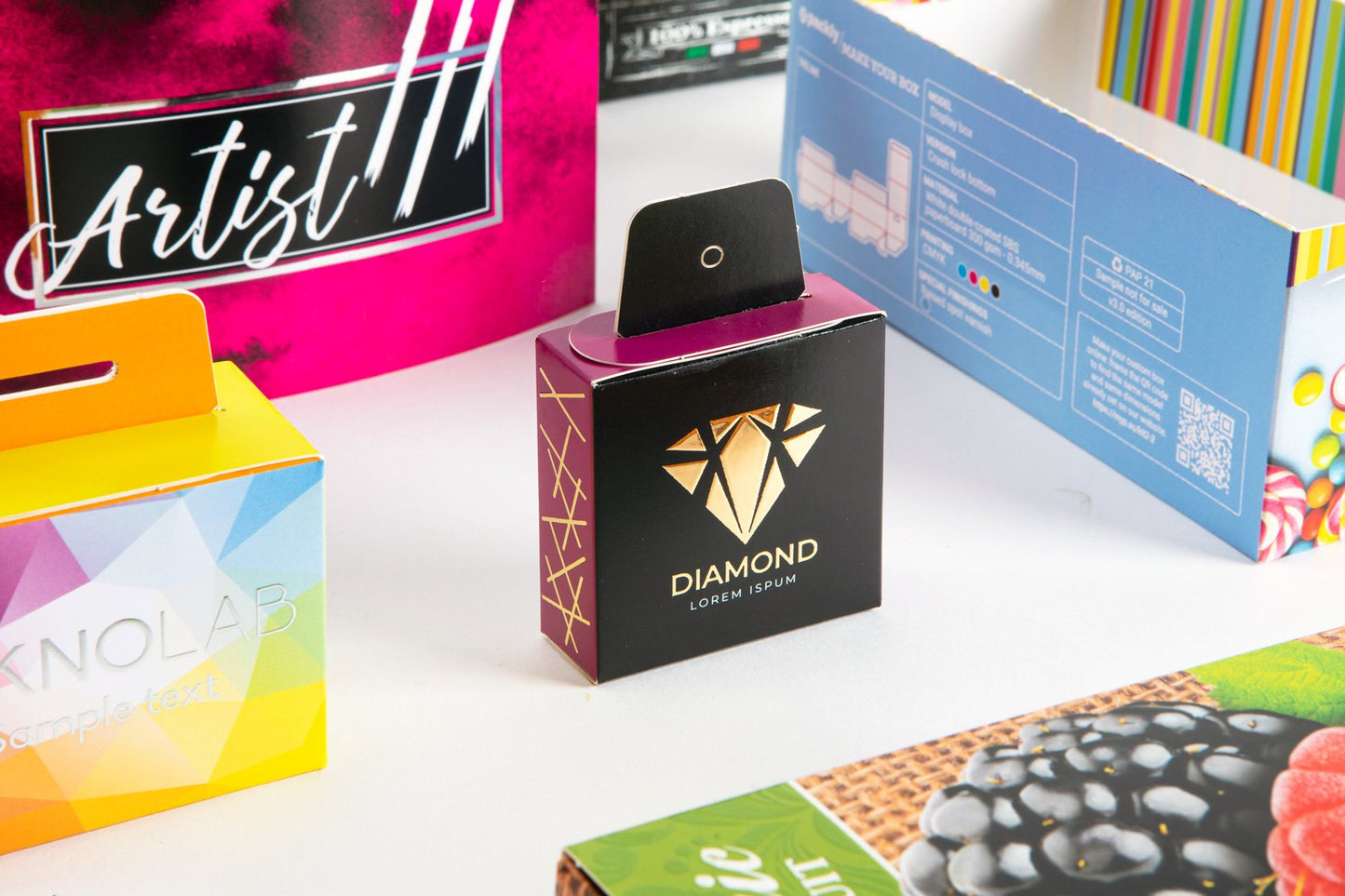 Four boxes with different designs, one in the center, black and purple with gold special finishes, focused on in the photo.